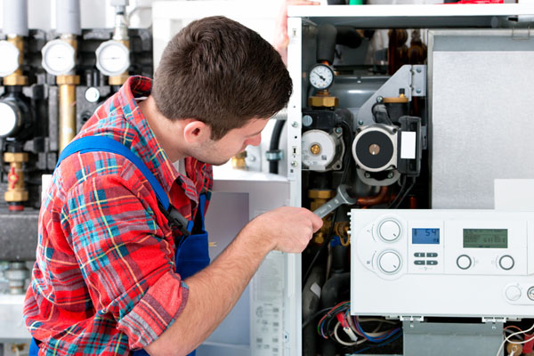 HVAC technician inspecting and repairing boiler controls in Louisville