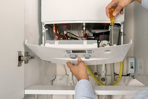 HVAC technician repairing an indoor boiler in Louisville