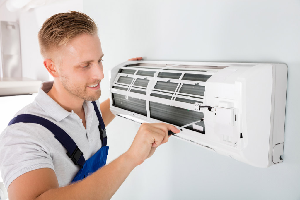 HVAC technician performing ductless air conditioning maintenance in Louisville