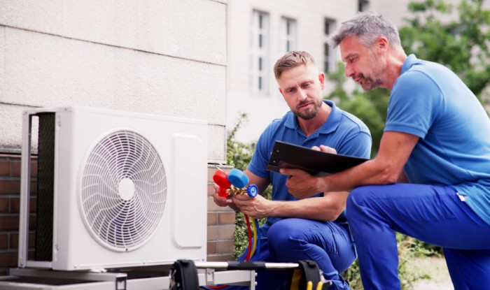 HVAC technicians installing an outdoor air conditioning unit in Louisville