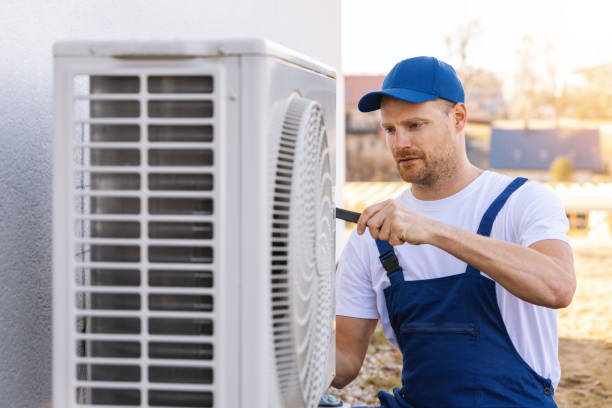 HVAC technician servicing an outdoor air conditioning unit in Louisville