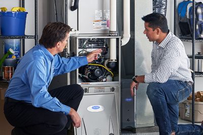 65df8c11f3e4c468cbd351a5_furnace repair vs replacement – Copy HVAC technician explaining furnace repair and maintenance to a homeowner in Louisville, CO