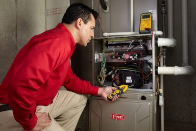 furnace repair Heating and air conditioning technician servicing an indoor furnace in Louisville, CO